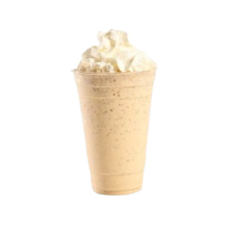 A Peri Peri Original milkshake, light brown with whipped cream, in a clear plastic cup.
