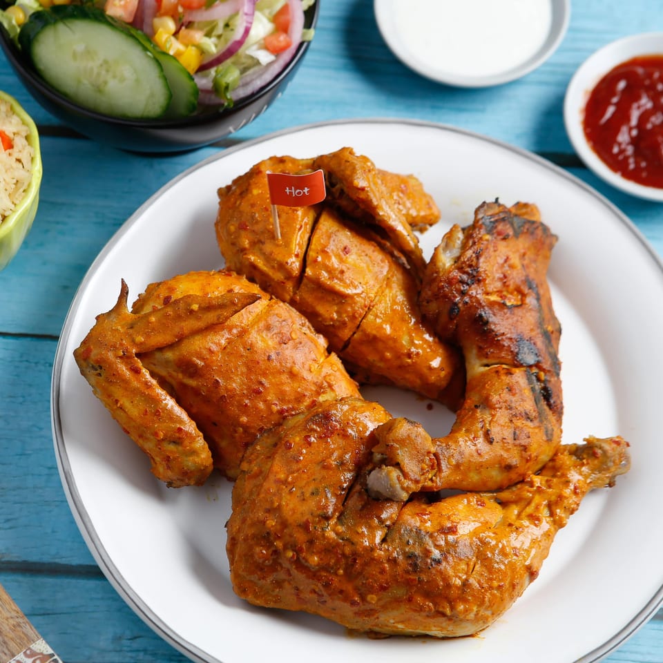 Peri Peri Original's hot peri peri chicken with a side of salad, rice, and sauces.