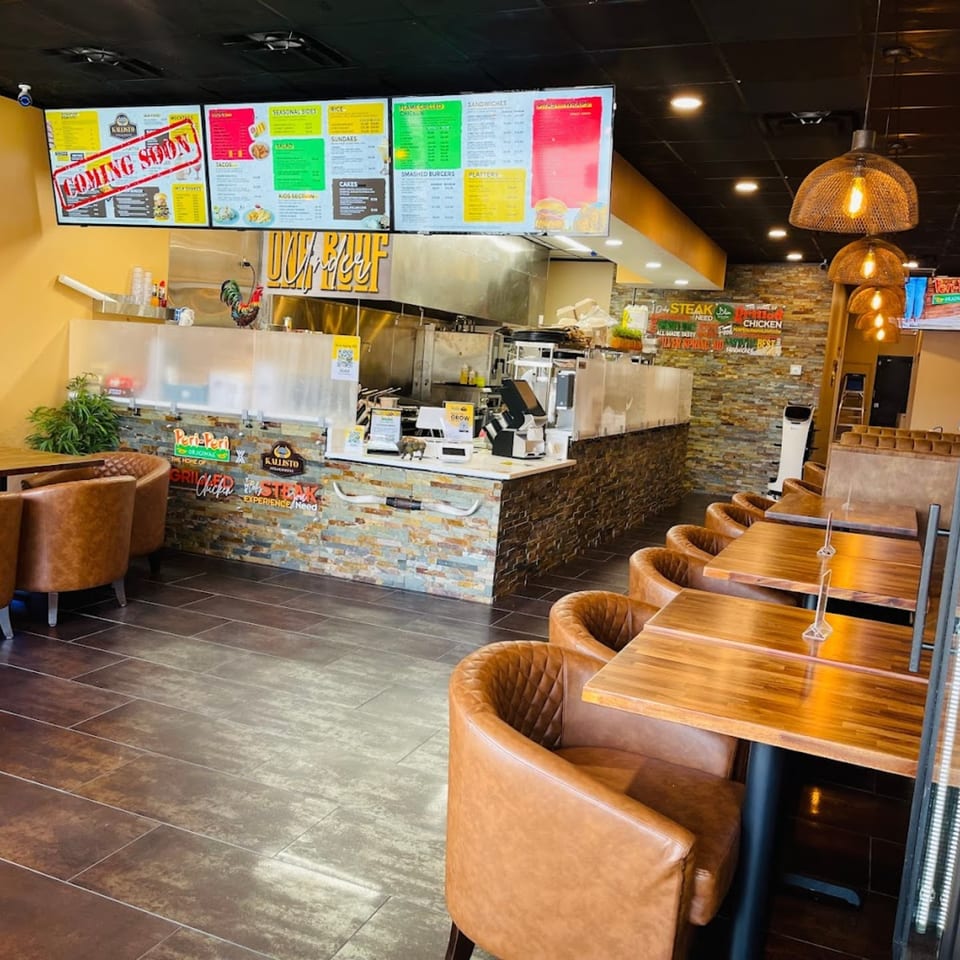 Interior of Peri Peri Original & Kallisto Steakhouse, featuring a counter, menu boards, and seating.